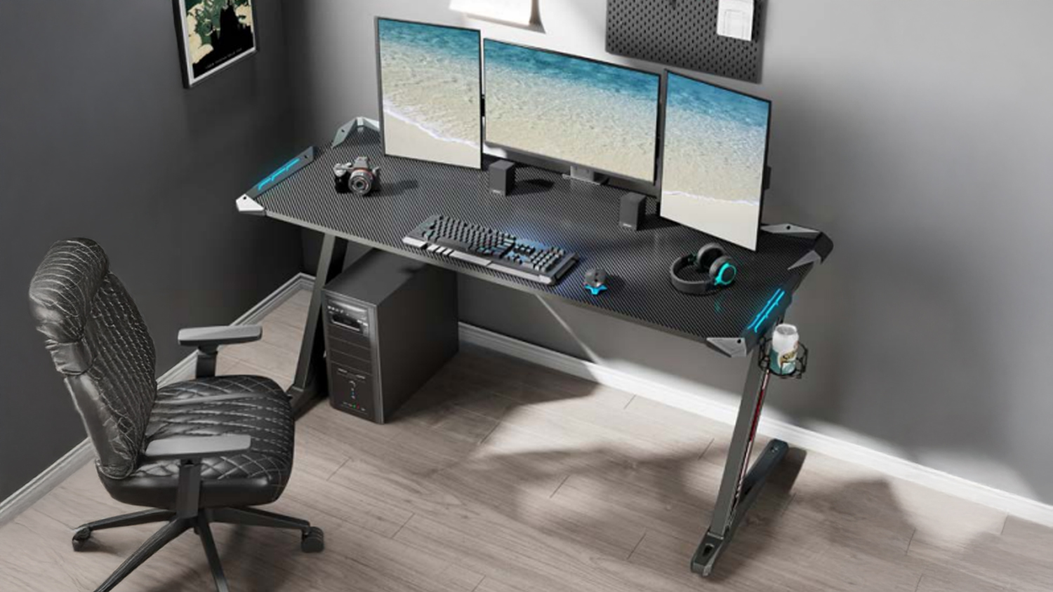 Black Z-shaped gaming desk with two monitors, a laptop, headphones, and a chair in a room