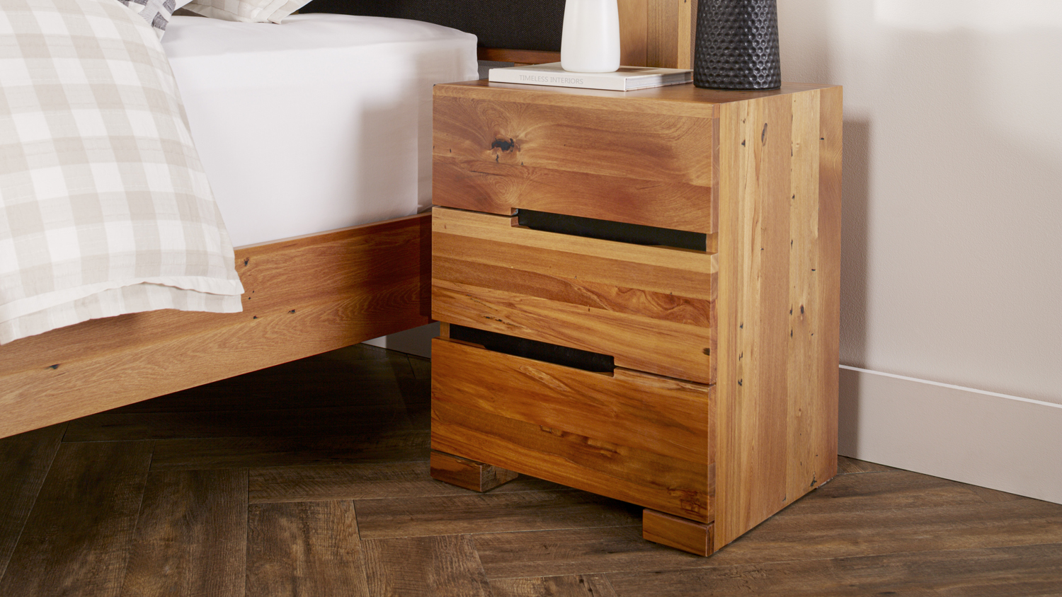 Nelson 3 Drawer Beside Table, left option with timeless wooden design, sitting on a dark wood floor