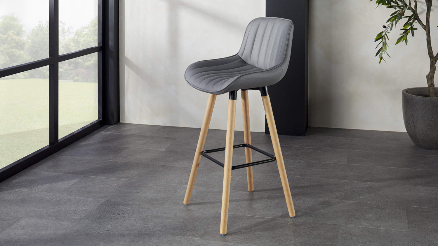 Marsden Bar Stool with a green upholstered seat, curved backrest, and four wooden legs with a metal footrest
