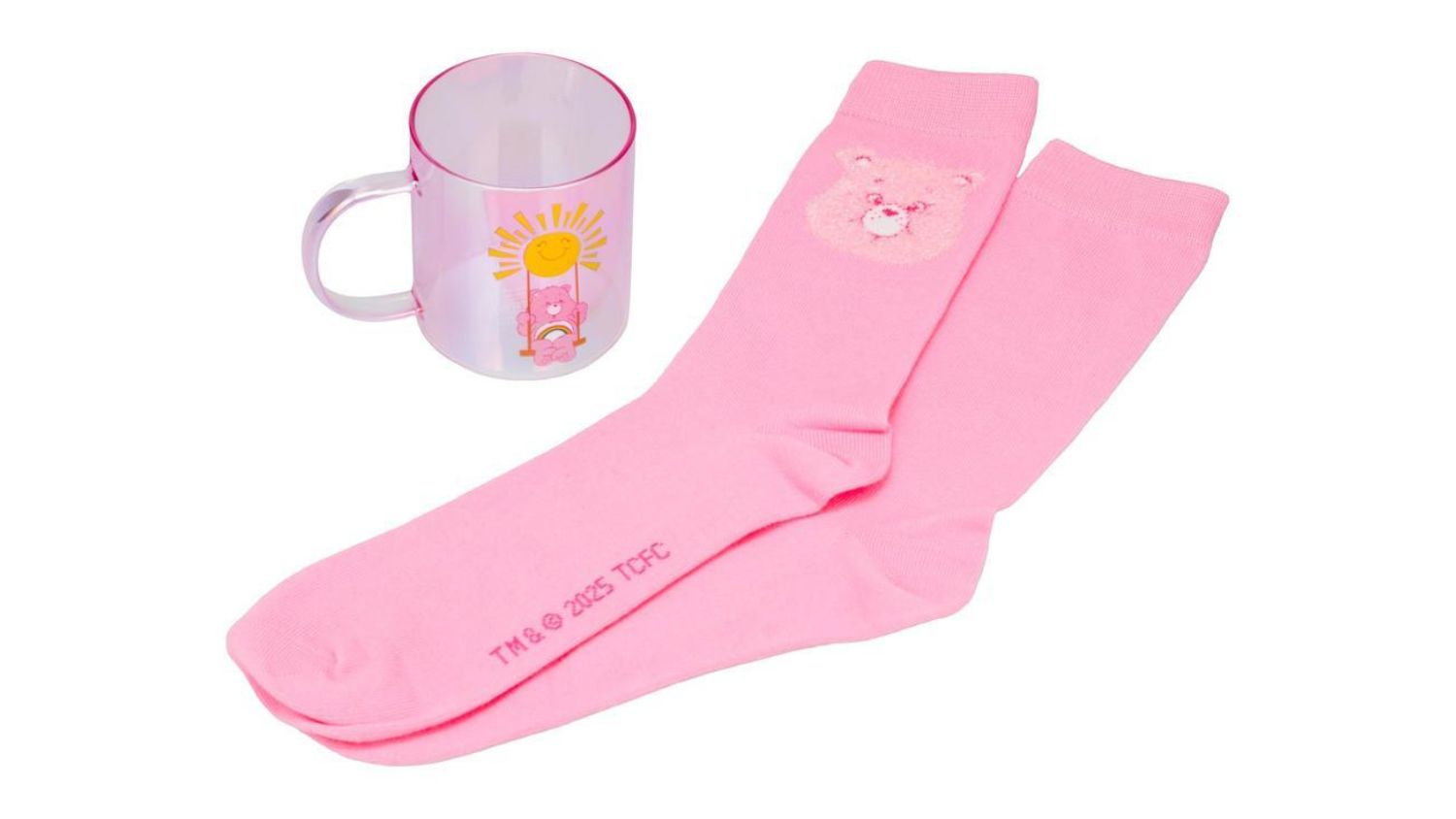 Pink Care Bears mug with Cheer Bear design next to matching pink socks featuring a bear face