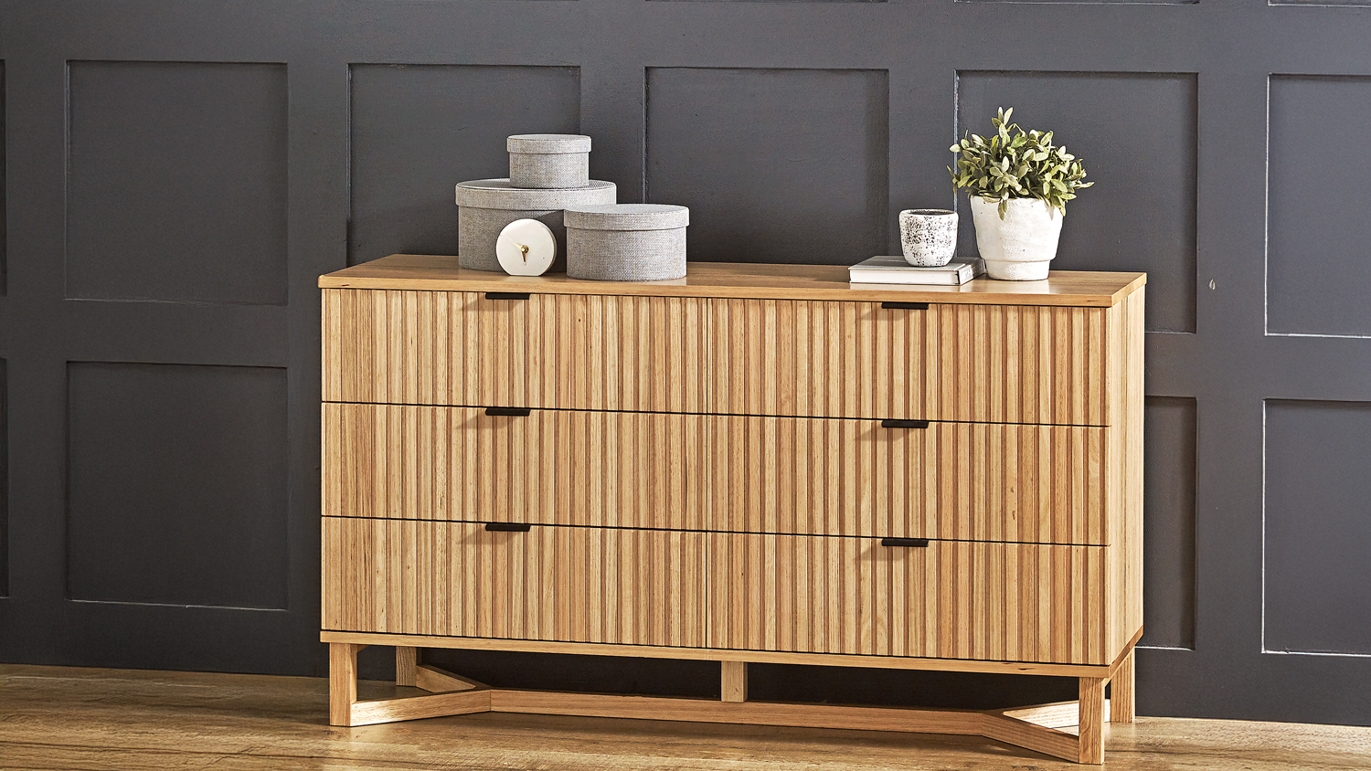 Wooden low chest of drawers with six wide slatted drawers and décor on top