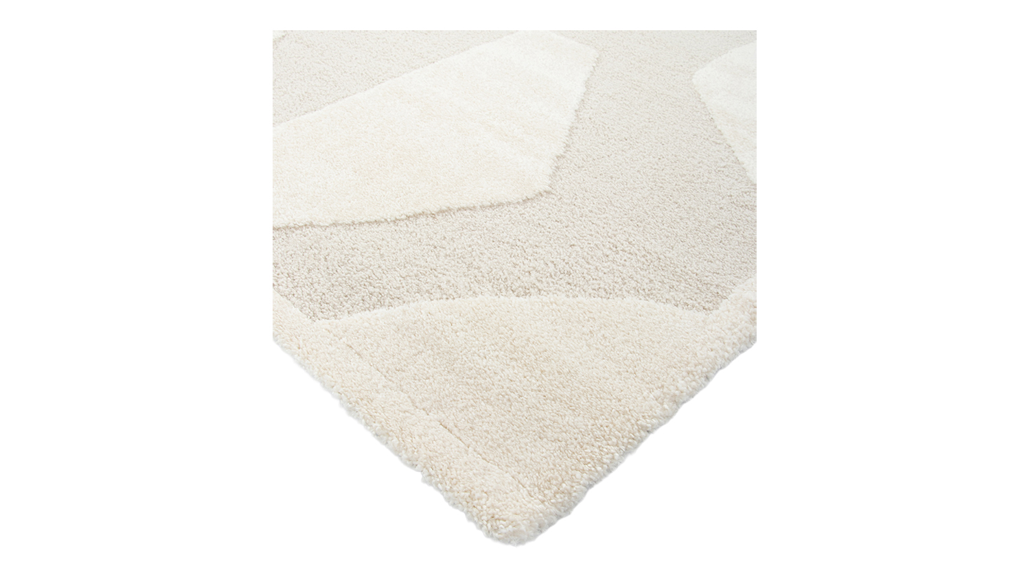 Close-up of a rug corner highlighting its plush 20mm cut pile and textured carved design in ivory and beige tones