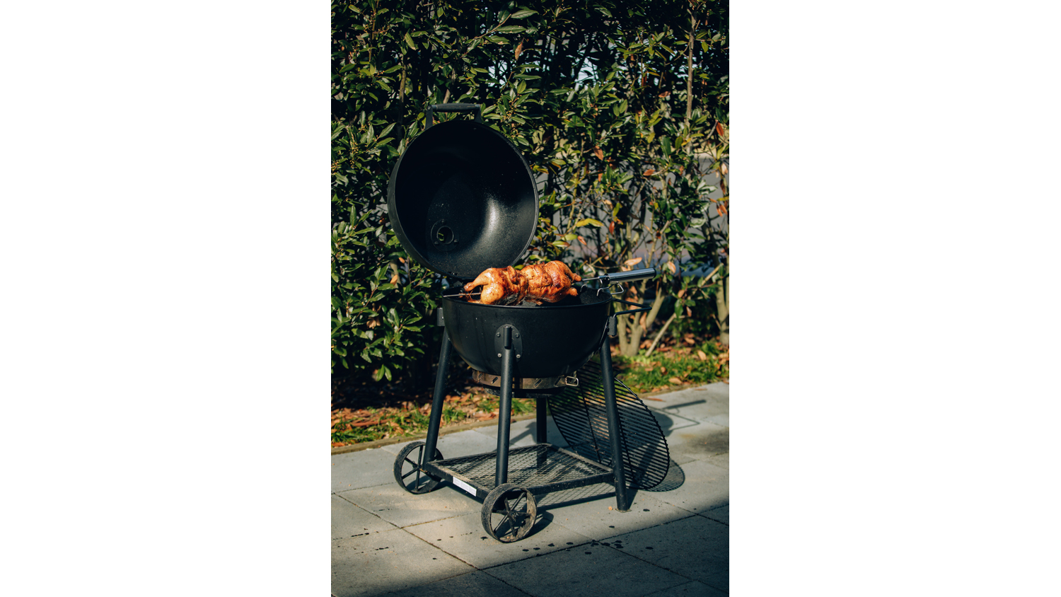 A full view of a barbecue with the rotisserie kit set up in it