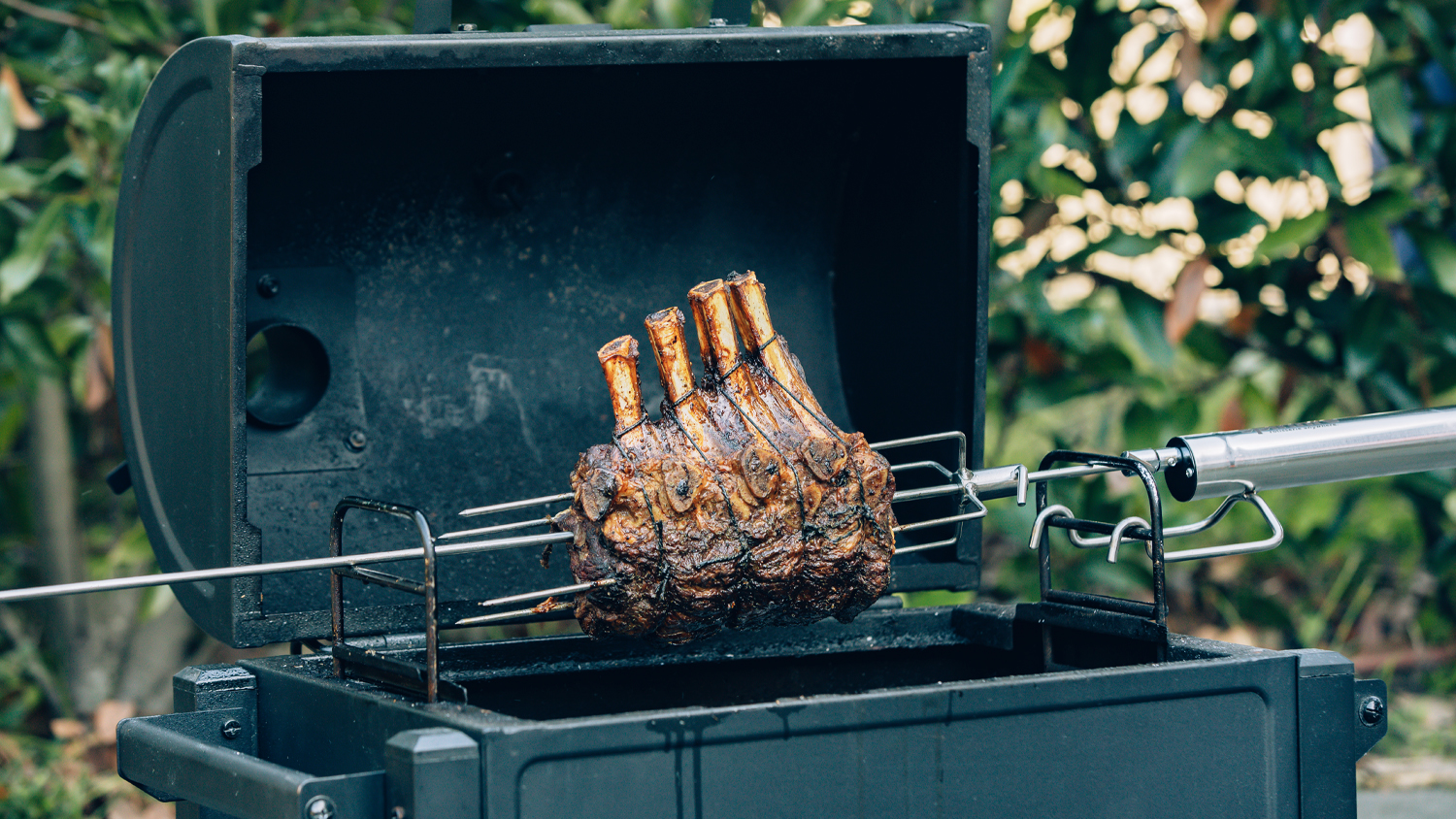 The Santo Premium 6 Piece BBQ Rotisserie Kit set up on a barbecue