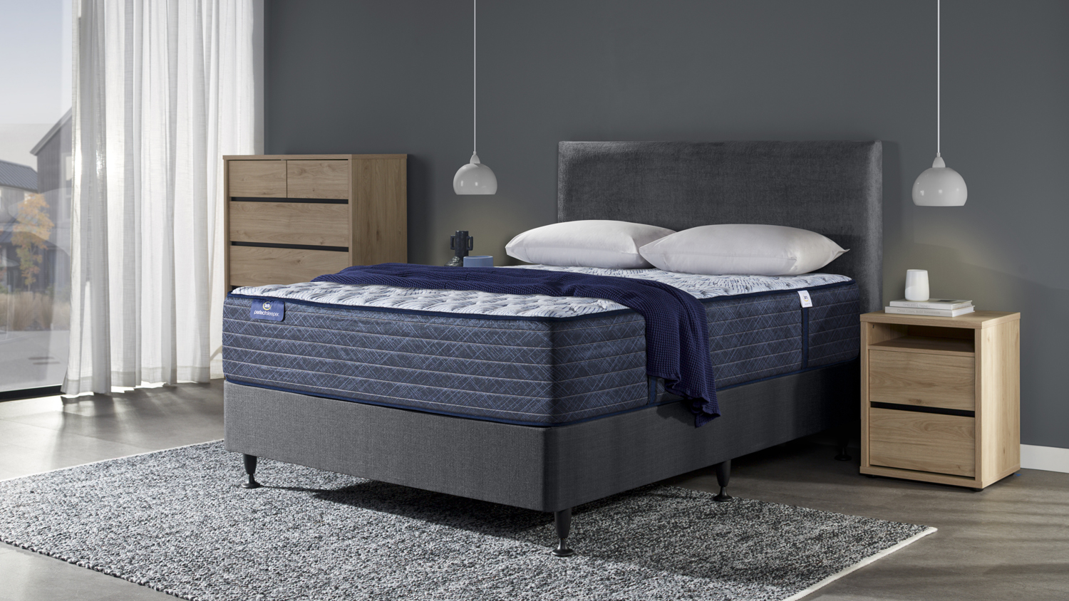 Blue Lagoon Extra Firm Super King Mattress by Serta on a grey bed frame with pillows