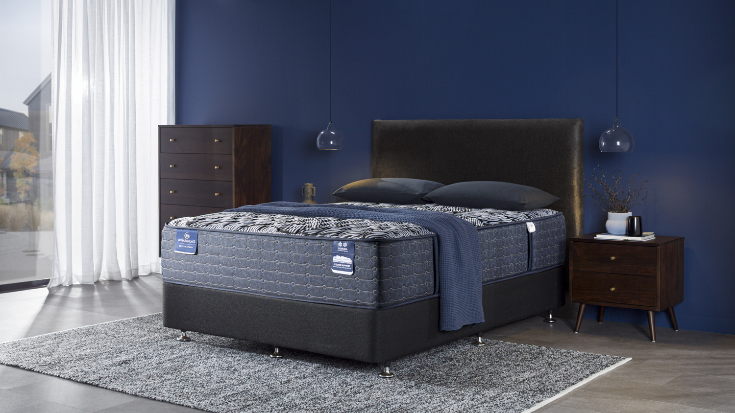 Lexton Extra Firm Californian King Mattress by Serta on a bed frame with pillows