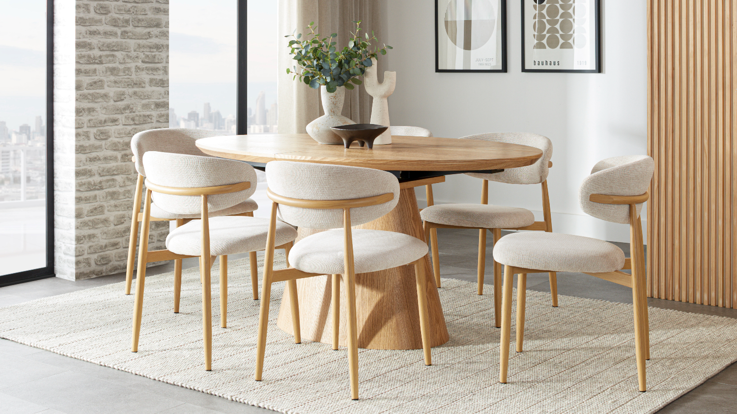 Ryder extension dining table in natural wood paired with six upholstered chairs, styled with vases