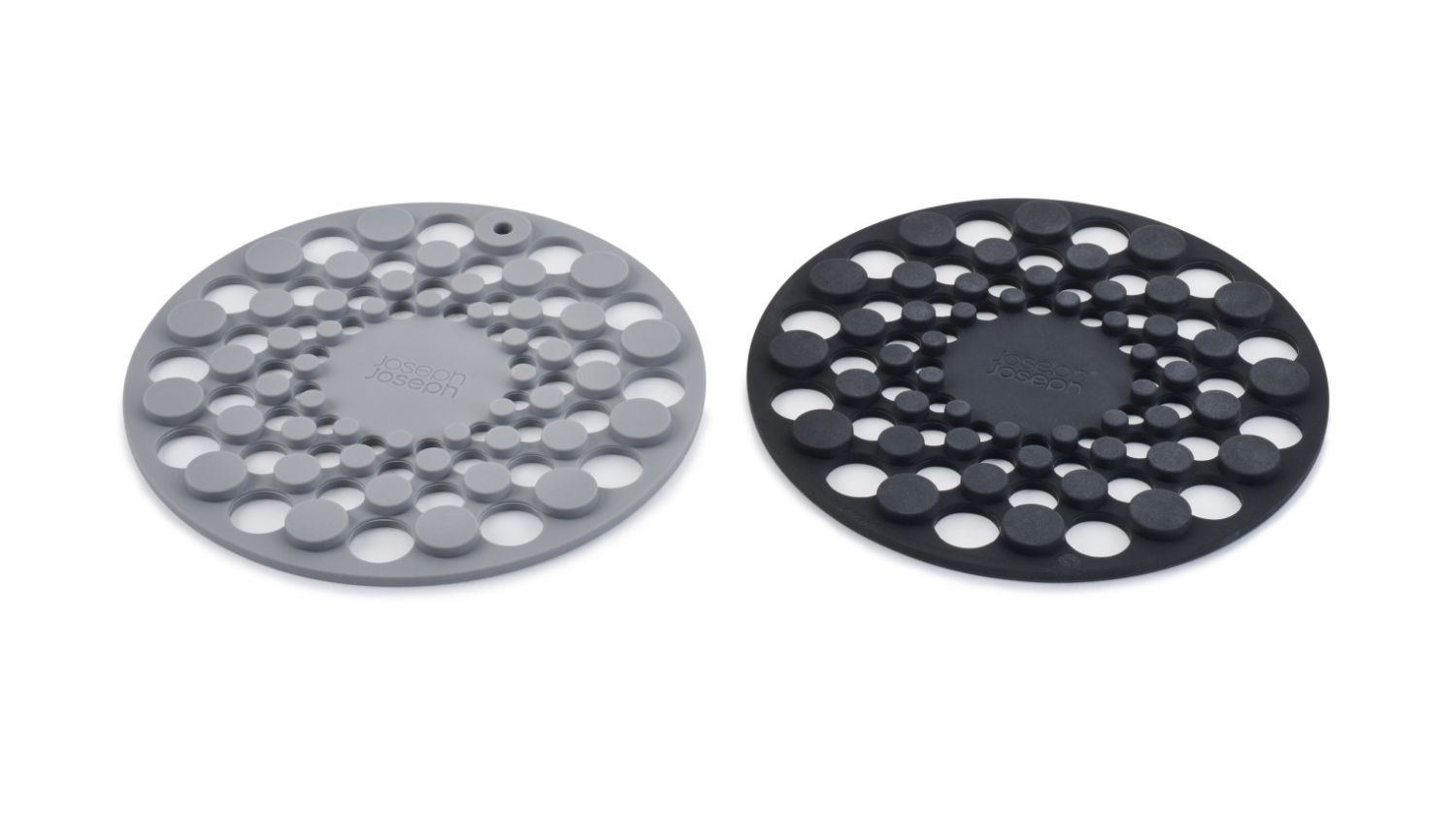 Two round silicone trivets in grey and black with a circular cutout design