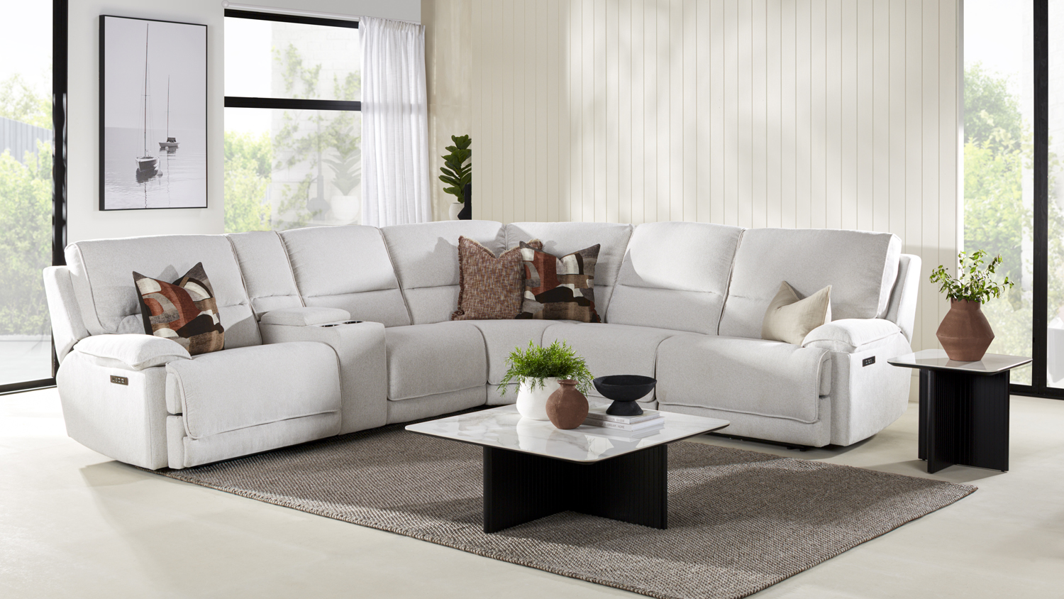 A large marshmallow-coloured L-shaped sectional sofa with multiple reclining seats and plush cushions