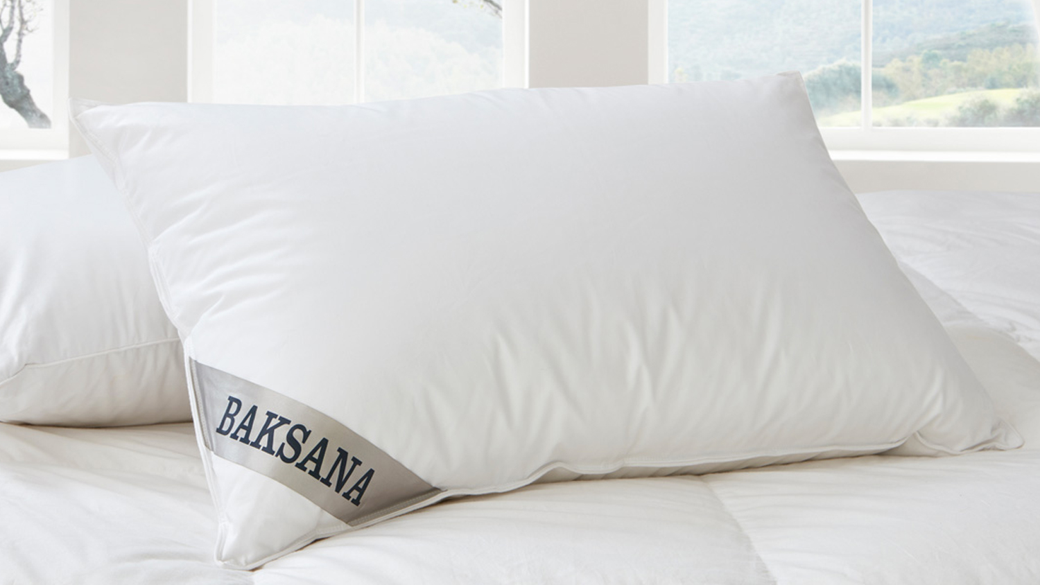Baksana Hungarian Goose Down & Feather Firm Pillow displayed on a bed with white linens
