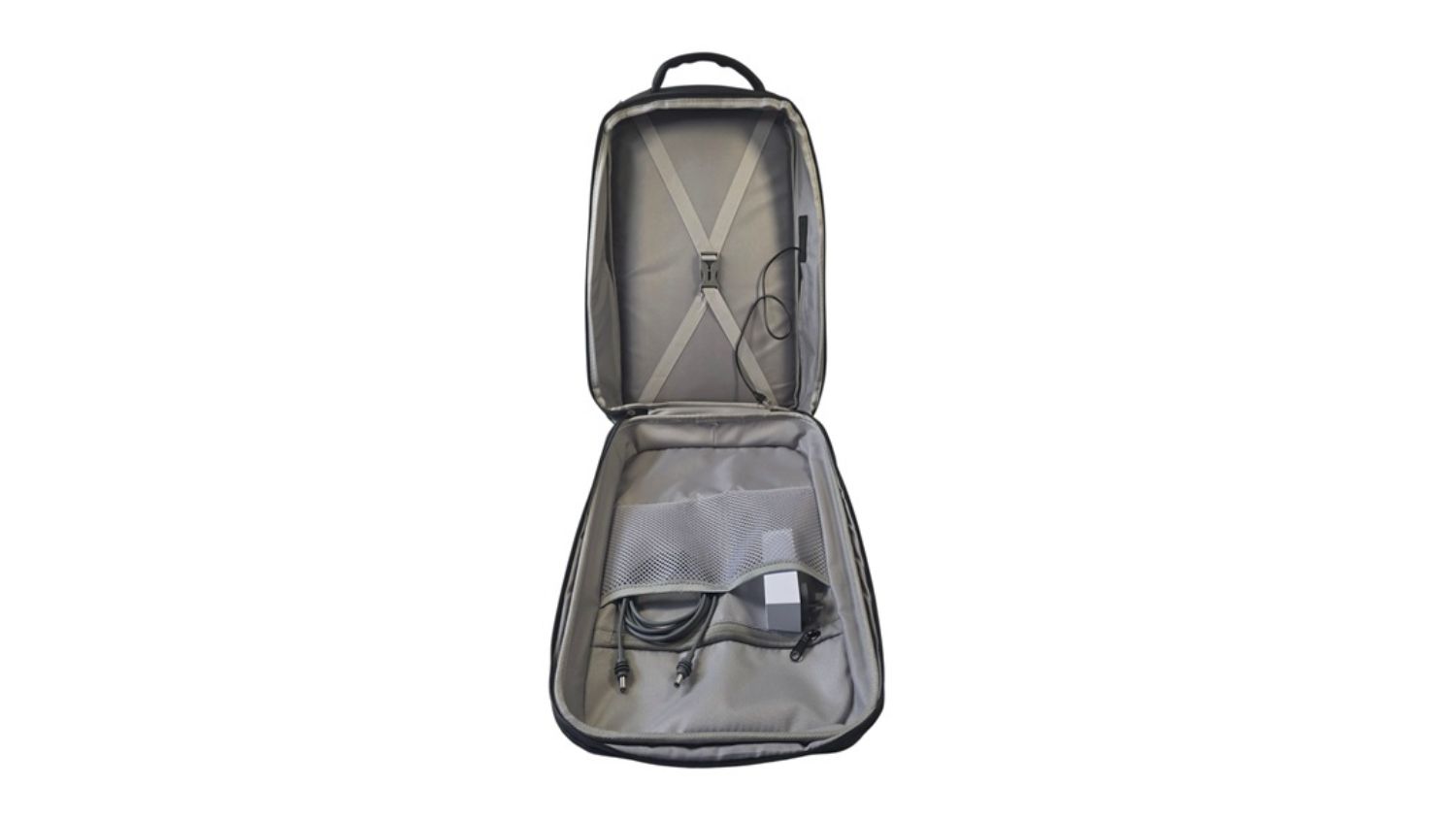 An open backpack displaying an organised interior with straps, a mesh pocket, and stored cables and accessories inside the main compartment