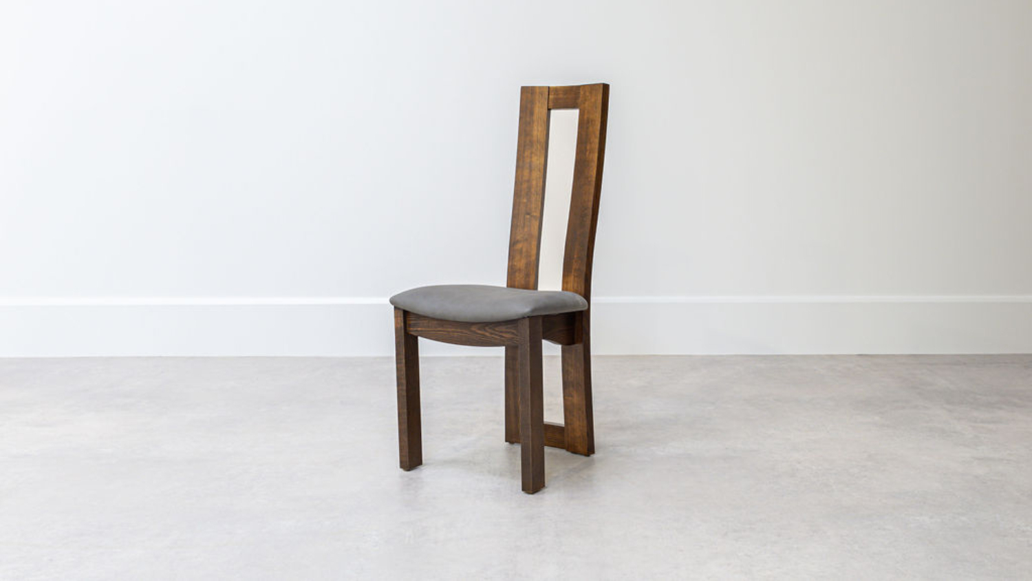 Front angled view of a wooden dining chair with a tall, narrow open-back frame and a curved cushioned seat