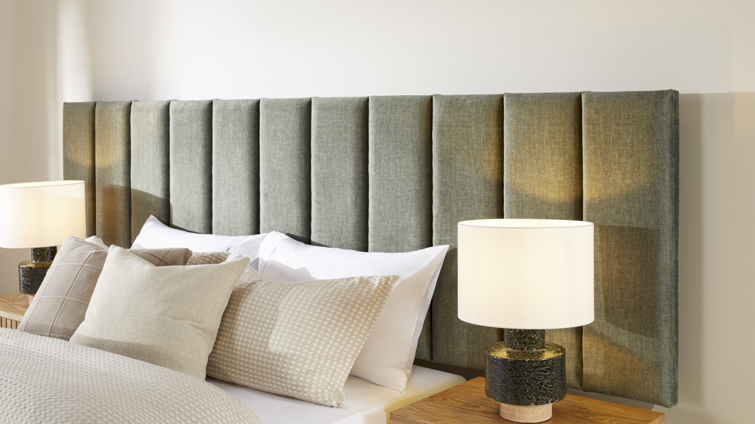 Luxury bedroom featuring an upholstered fluted headboard, white bedding, and accent pillows