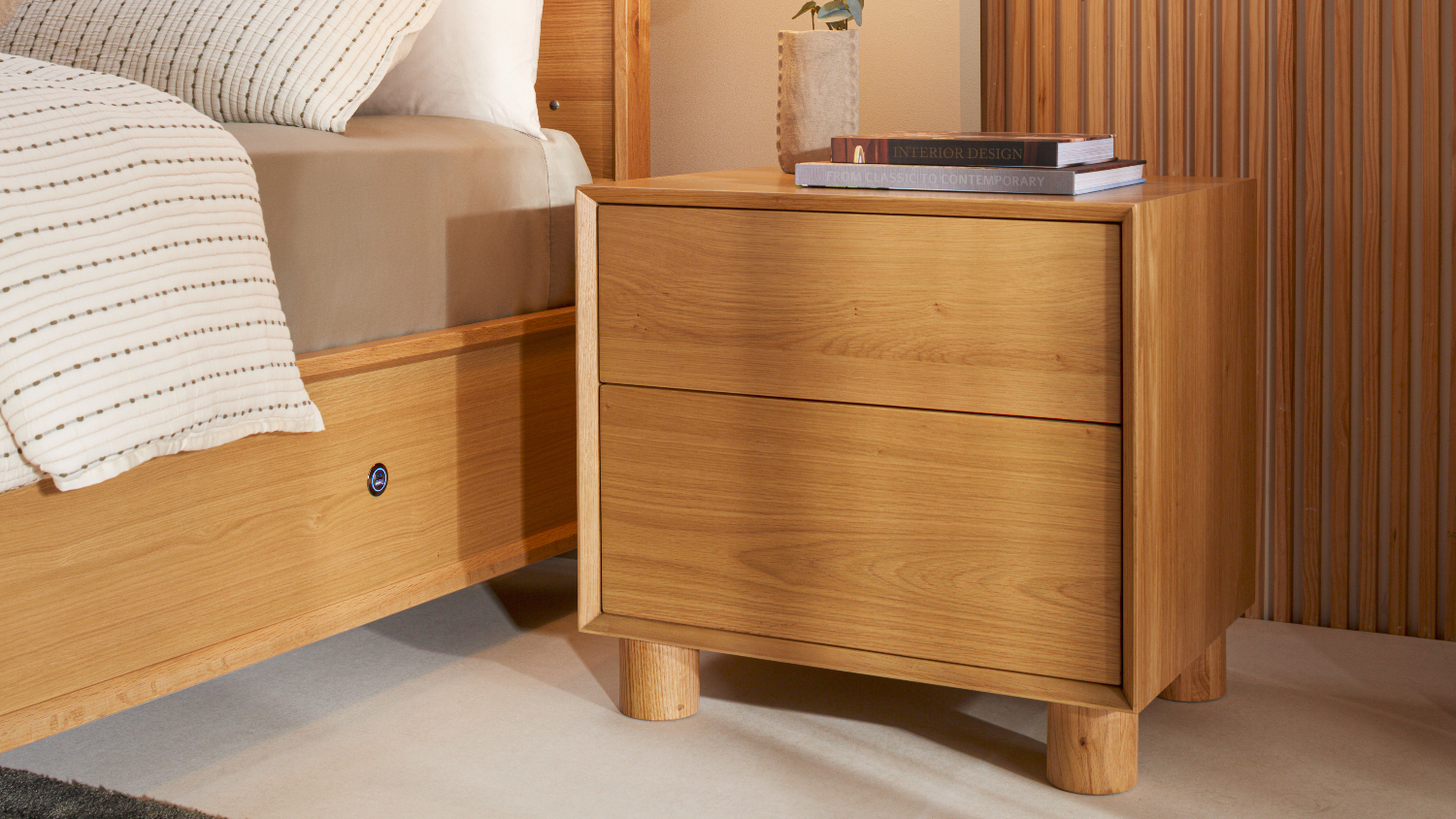 Jasper 2 Drawer Bedside Table shown beside a matching wooden bed