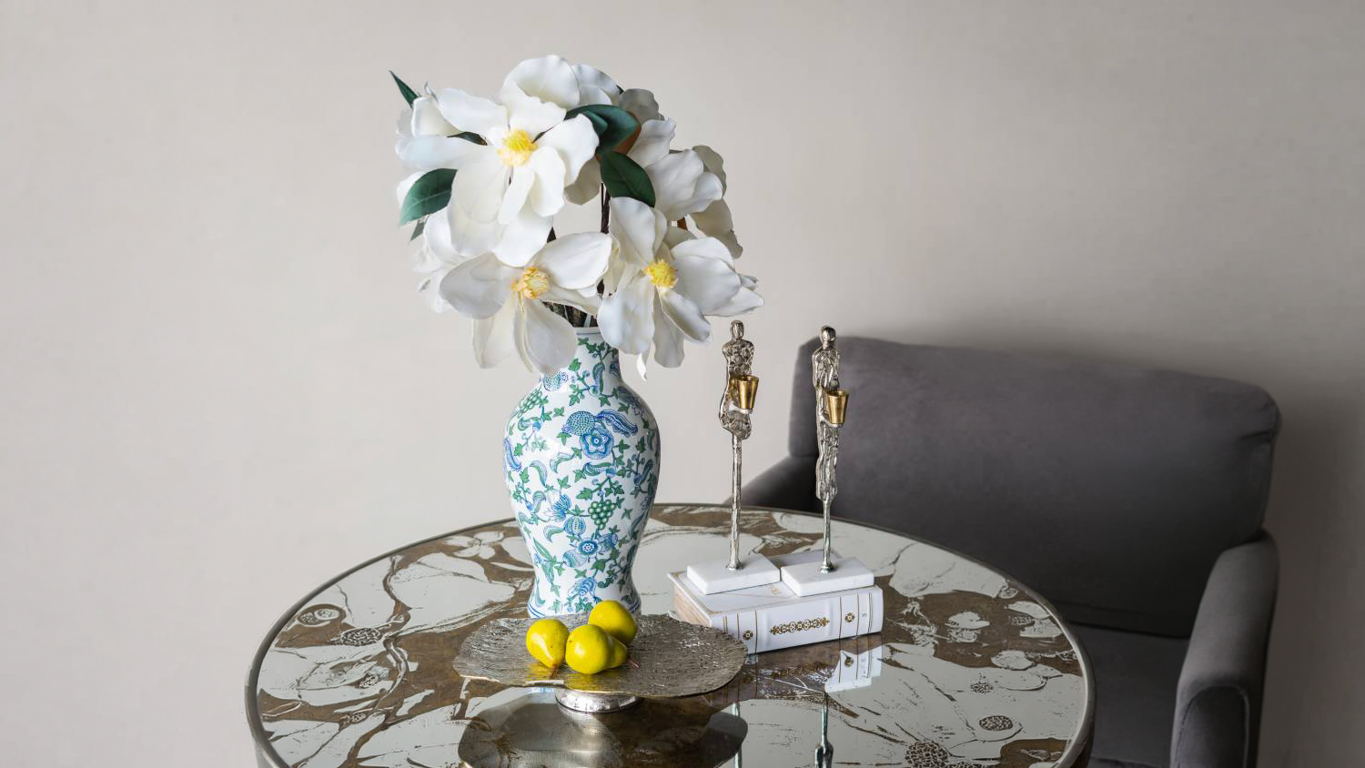 Styled interior scene showing the fluted porcelain vase placed on a mirrored tabletop