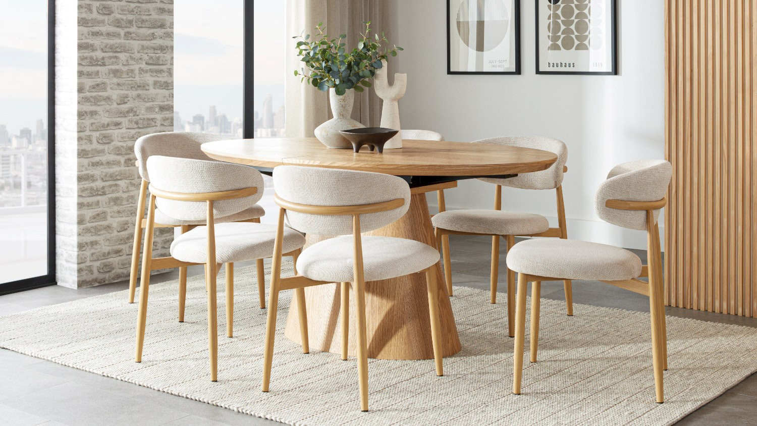 The Ryder 7 Piece Dining Suite featuring an oval wooden table and six matching cream upholstered chairs in a bright room