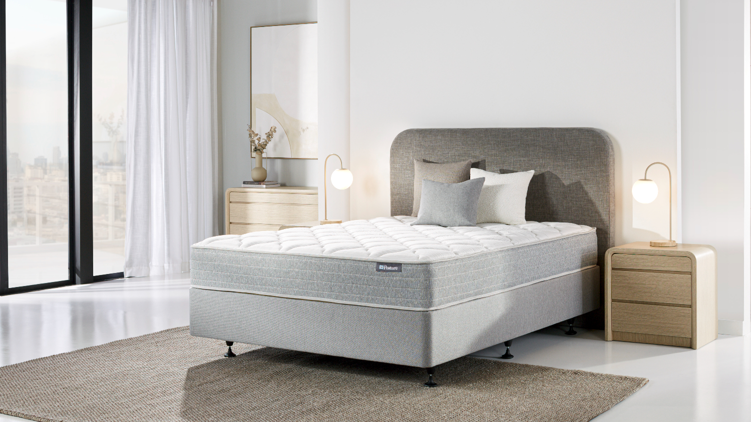 ull view of a Sealy Posture Life Comfort mattress and base set on a rug in a bright room