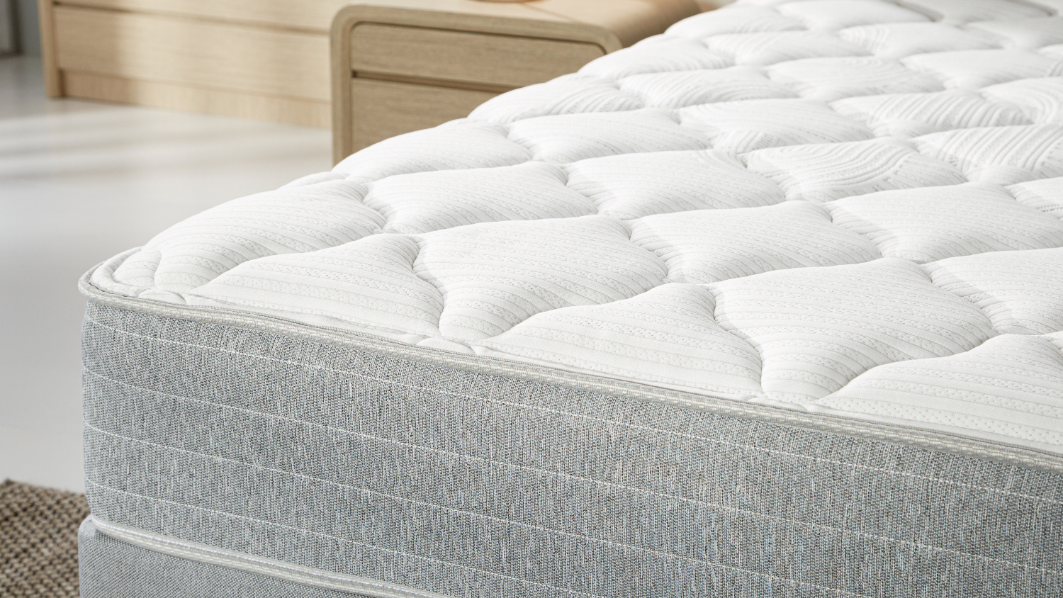 Detailed view of the plush, diamond-quilted white surface of a Sealy Posture Life Comfort mattress