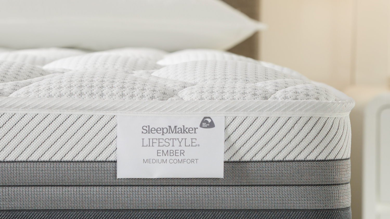 Close-up view of the Ember mattress with the SleepMaker brand tag