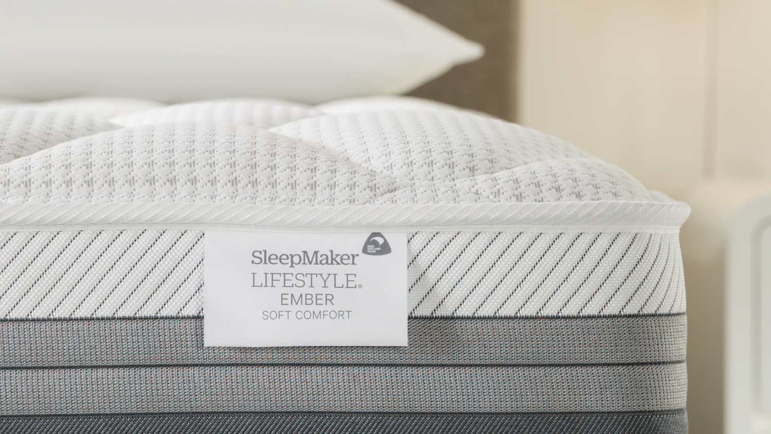 Close-up view of the Ember mattress with the SleepMaker brand tag