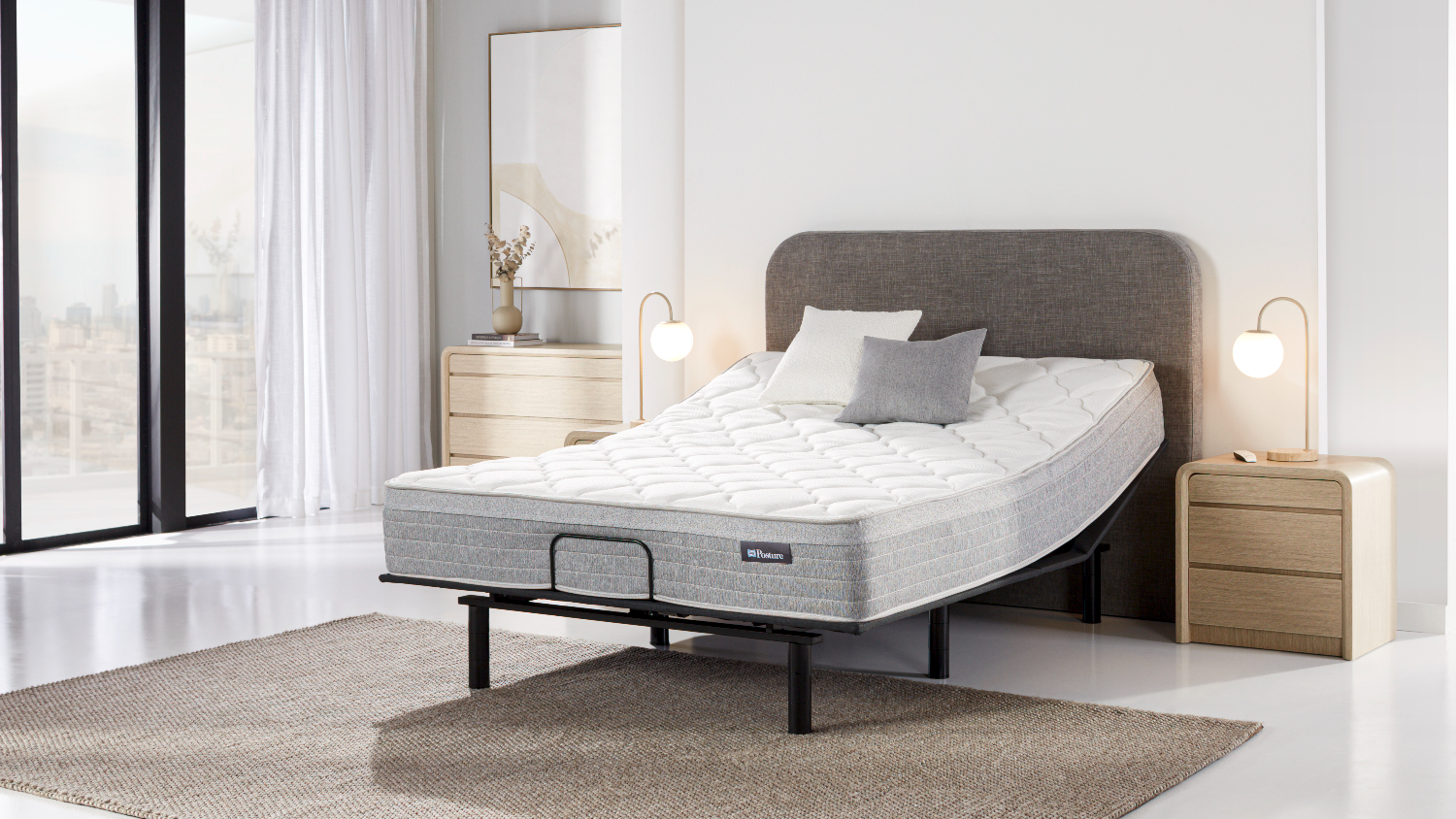 Angled bedroom view of a Sealy Posture Life Medium queen mattress on a Tempur Motion adjustable base