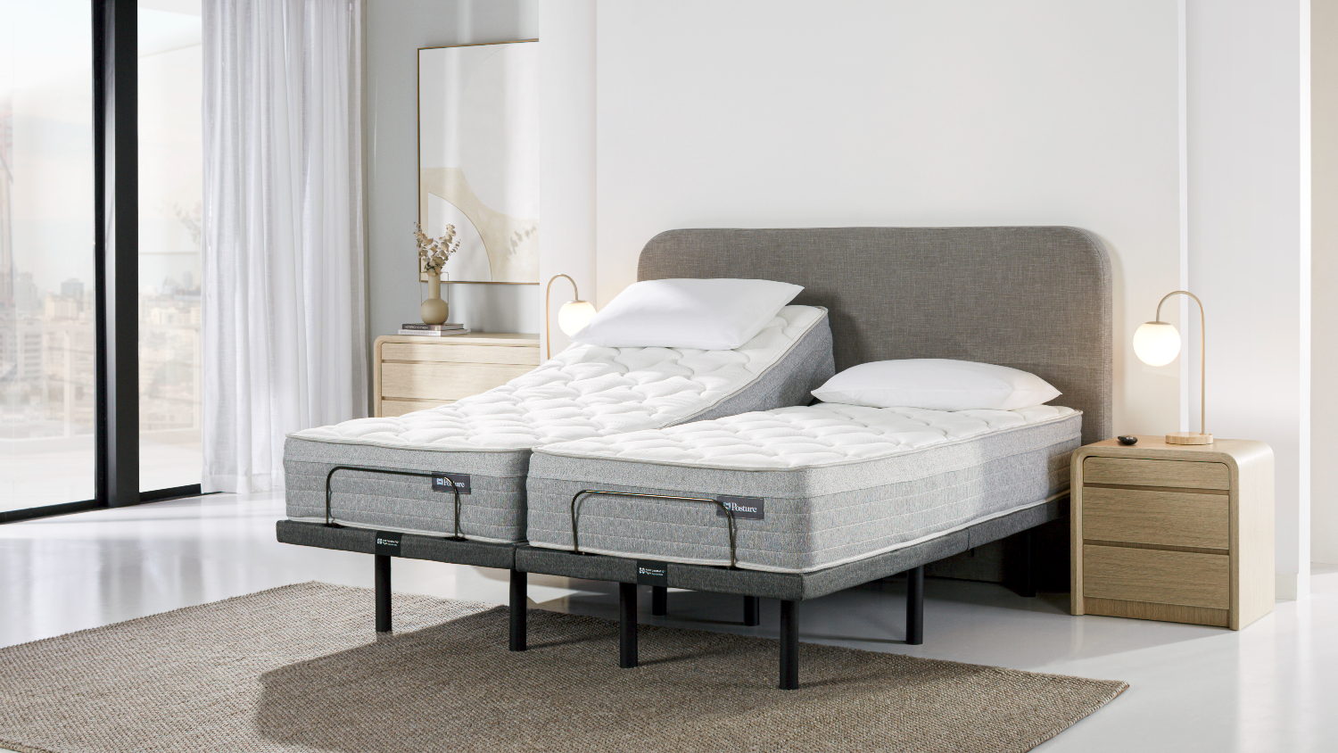 Angled bedroom view of a split queen Sealy Posture Life Comfort mattress on a Tempur Motion adjustable base