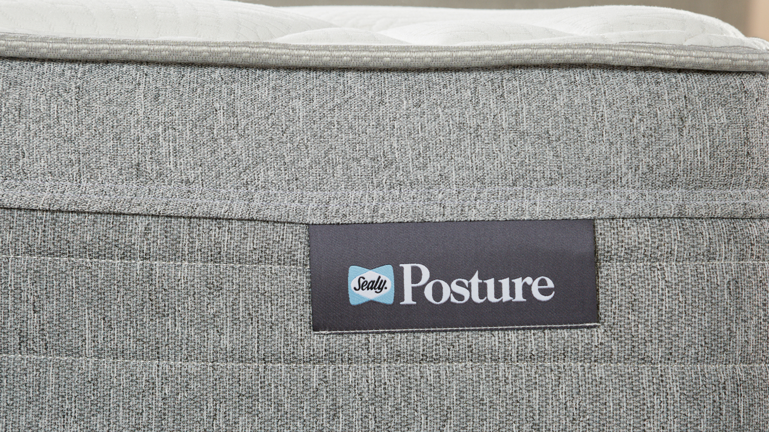 Detailed close‑up of the Sealy Posture brand tag sewn onto the mattress side