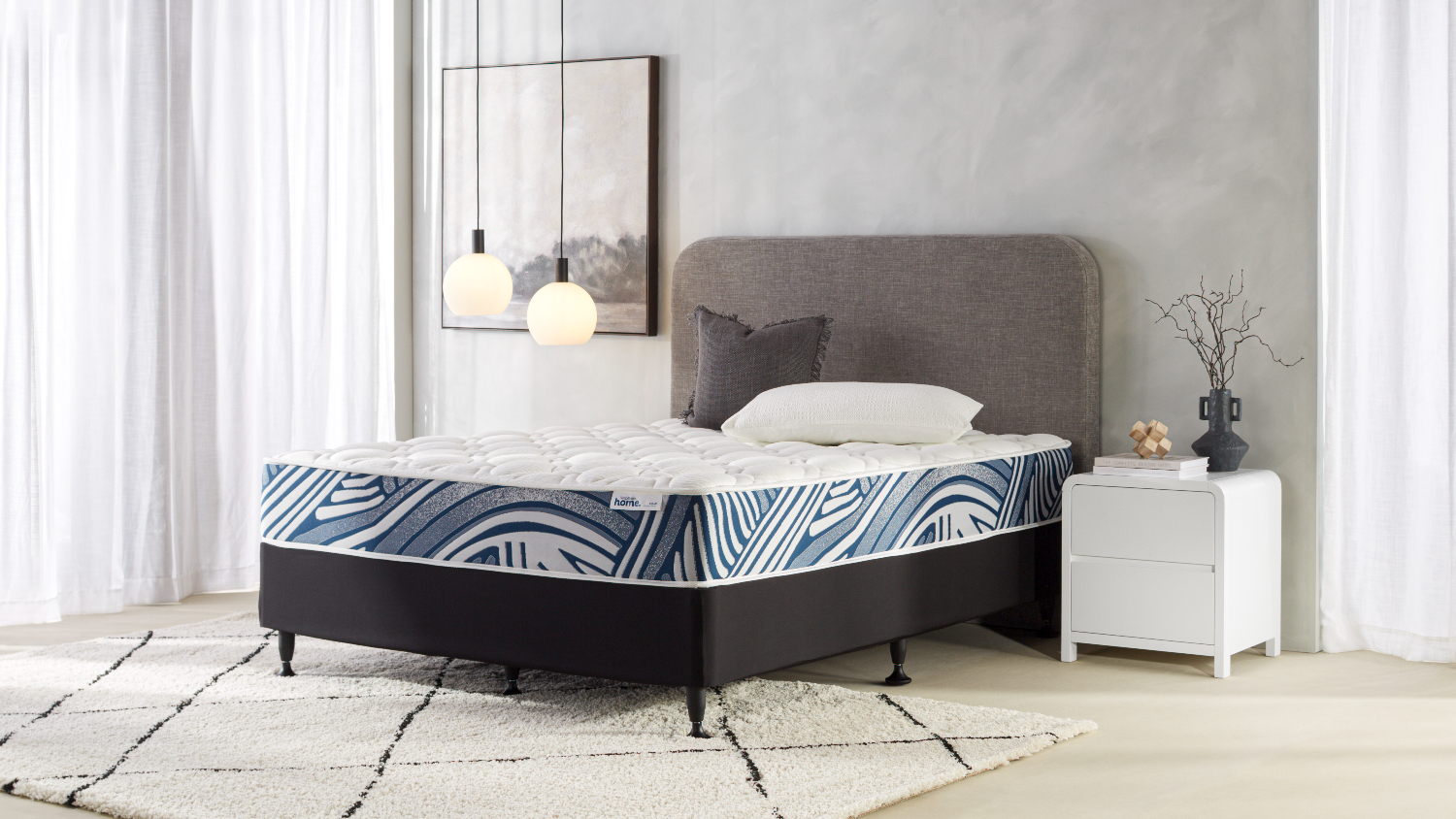 Side view of the finished bed setup, highlighting the black upholstered base, short legs, and neatly fitted mattress