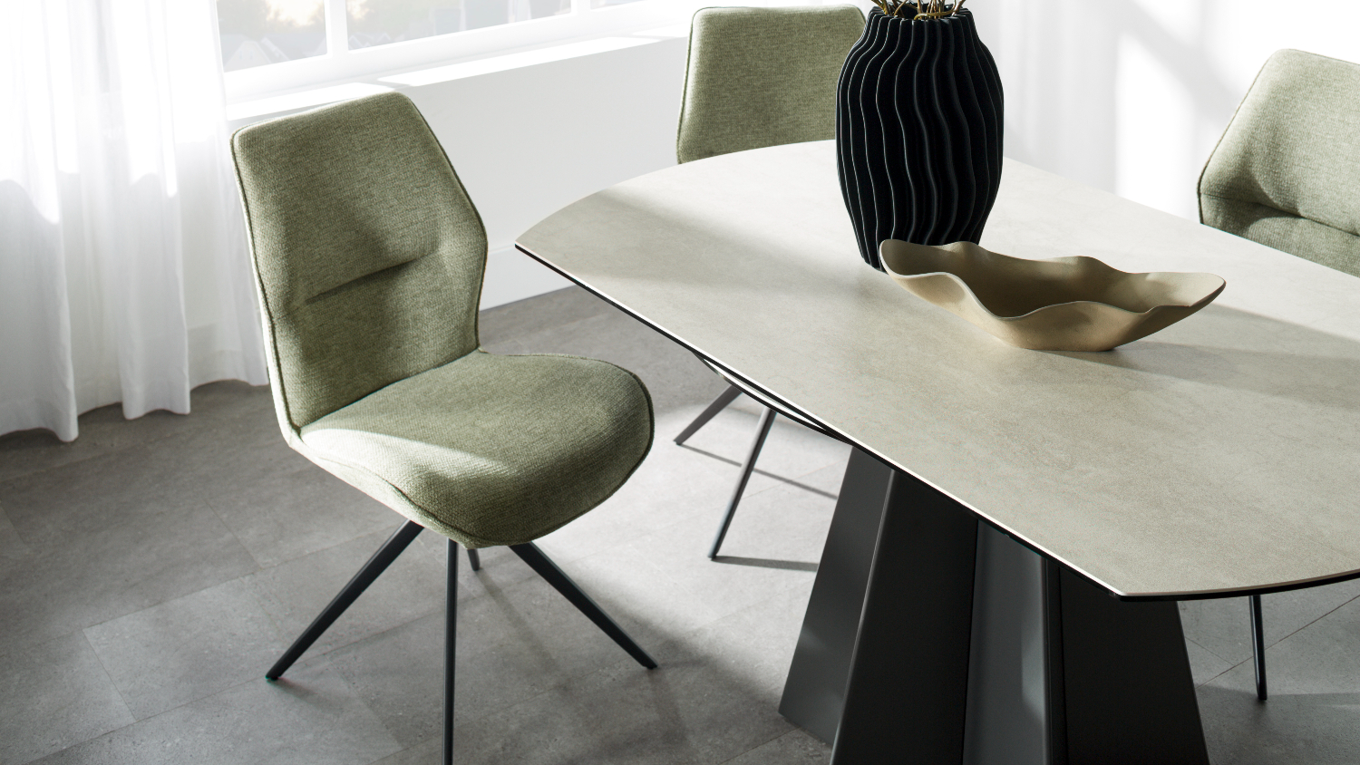 Close-up of the light oval tabletop with softly rounded edges and subtle texture, next to an olive upholstered chair
