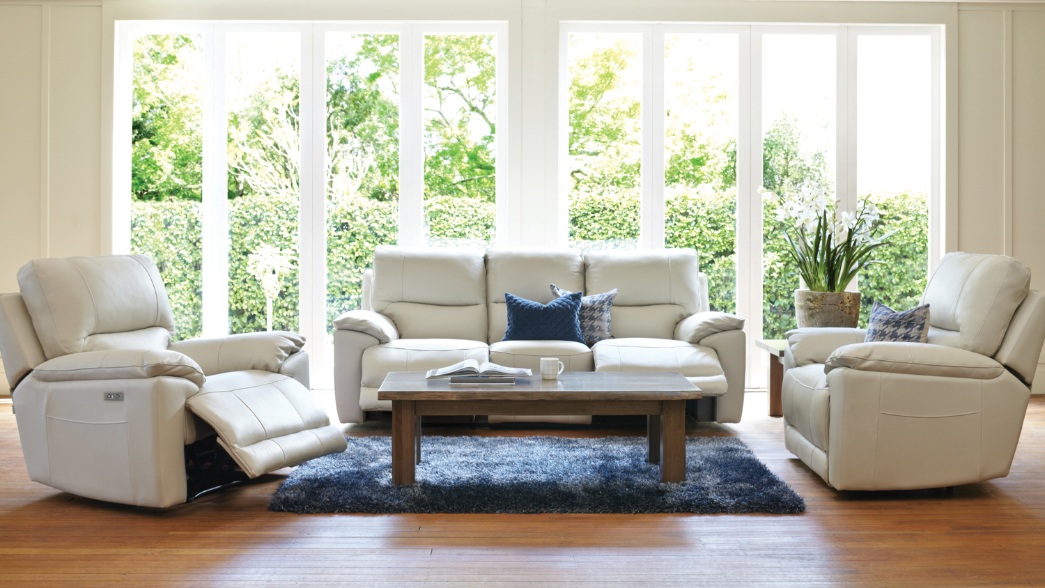 Featherstone leather recliner lounge suite with the left armchair extended, showing the raised footrest