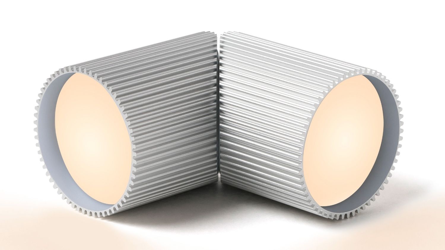 Rear angle view of Lexon Ray small aluminium LED lights placed back‑to‑back, highlighting textured cylindrical housing