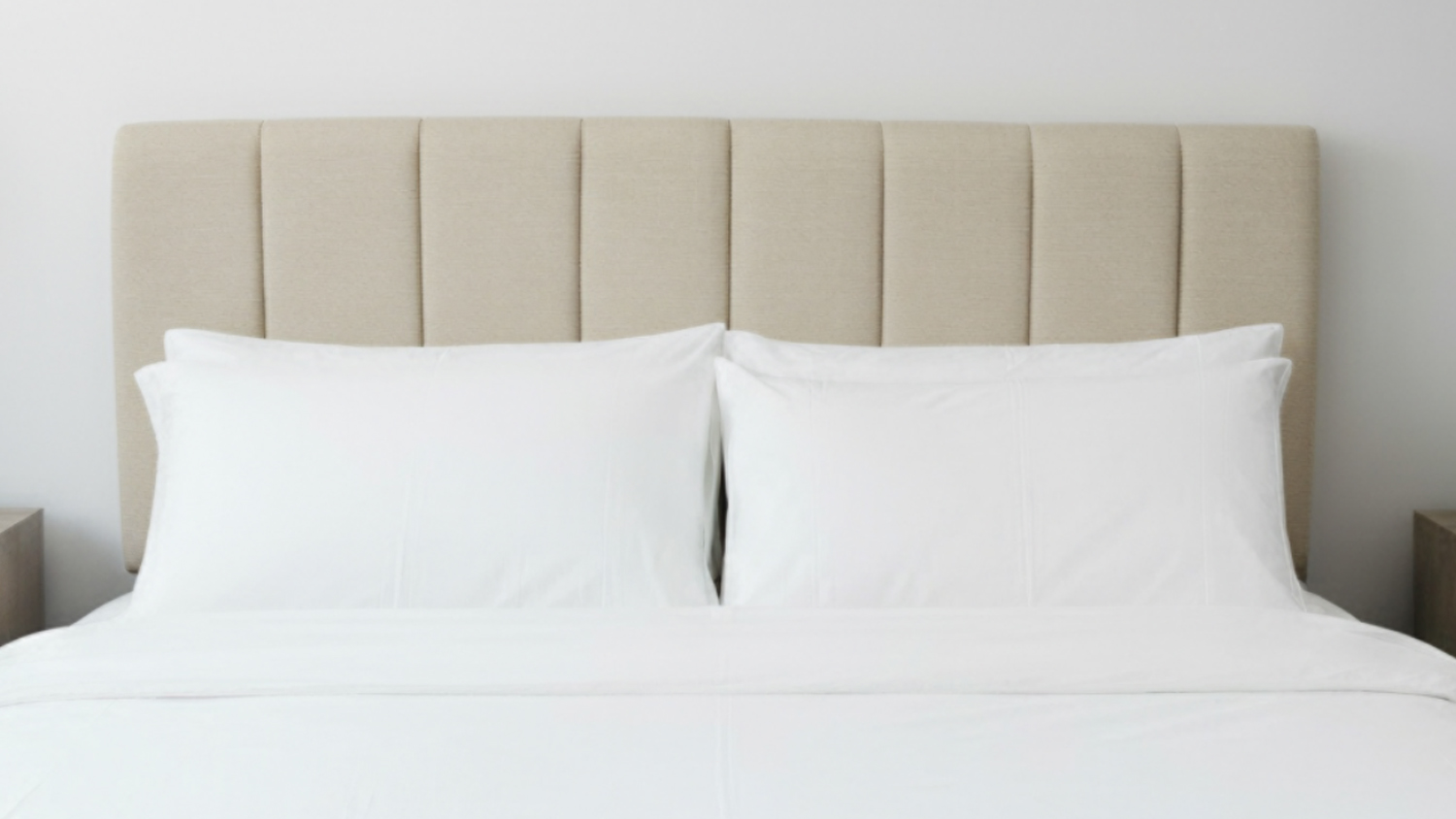 Nile Super King upholstered headboard fabric with vertical panels, paired with white pillows in a bedroom setting