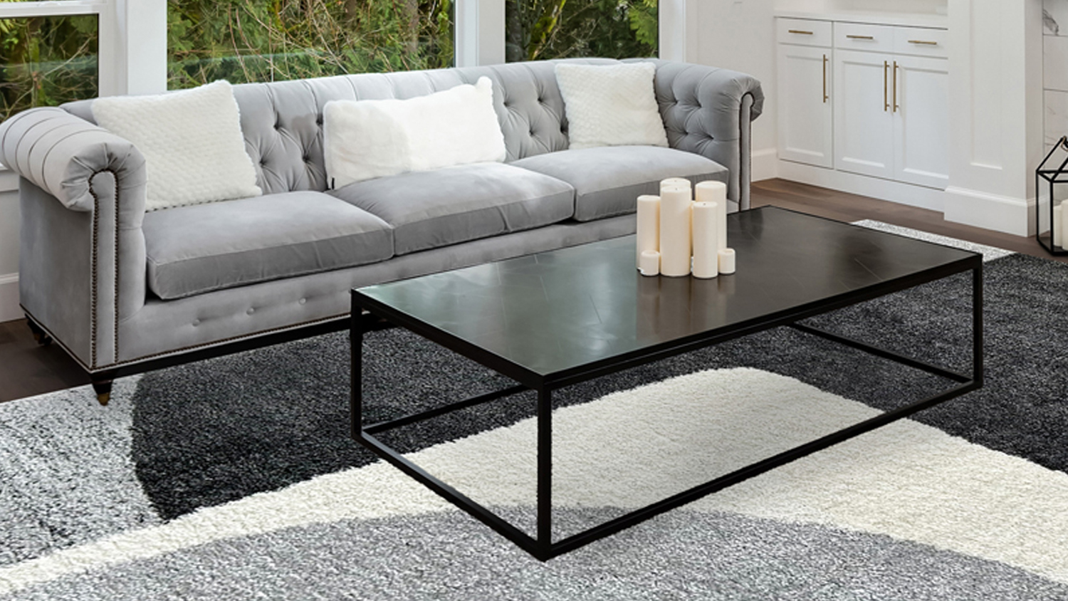 Modern living room featuring the plush Laine rug with a geometric grey, black, and white block pattern