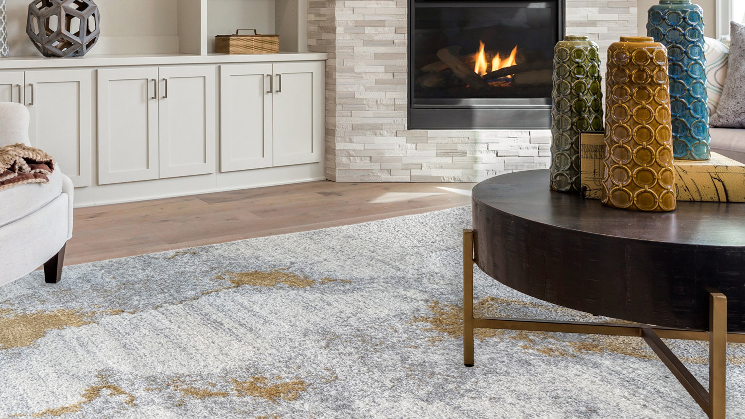 Modern living room featuring the plush Laine rug with a gold, cream, and grey colour palette