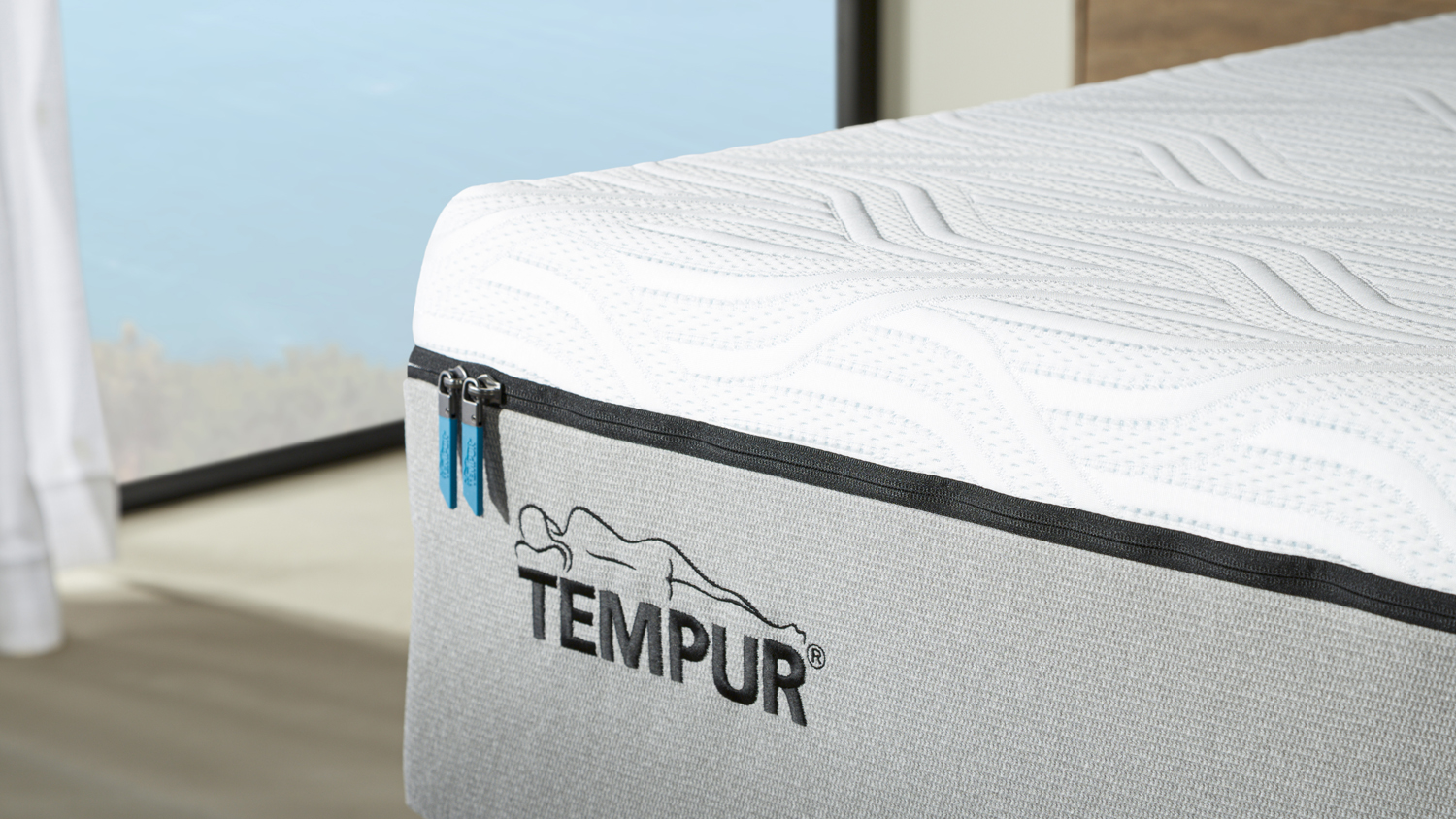 Detailed view showing the Tempur embroidered logo and premium zipper finish on the mattress cover