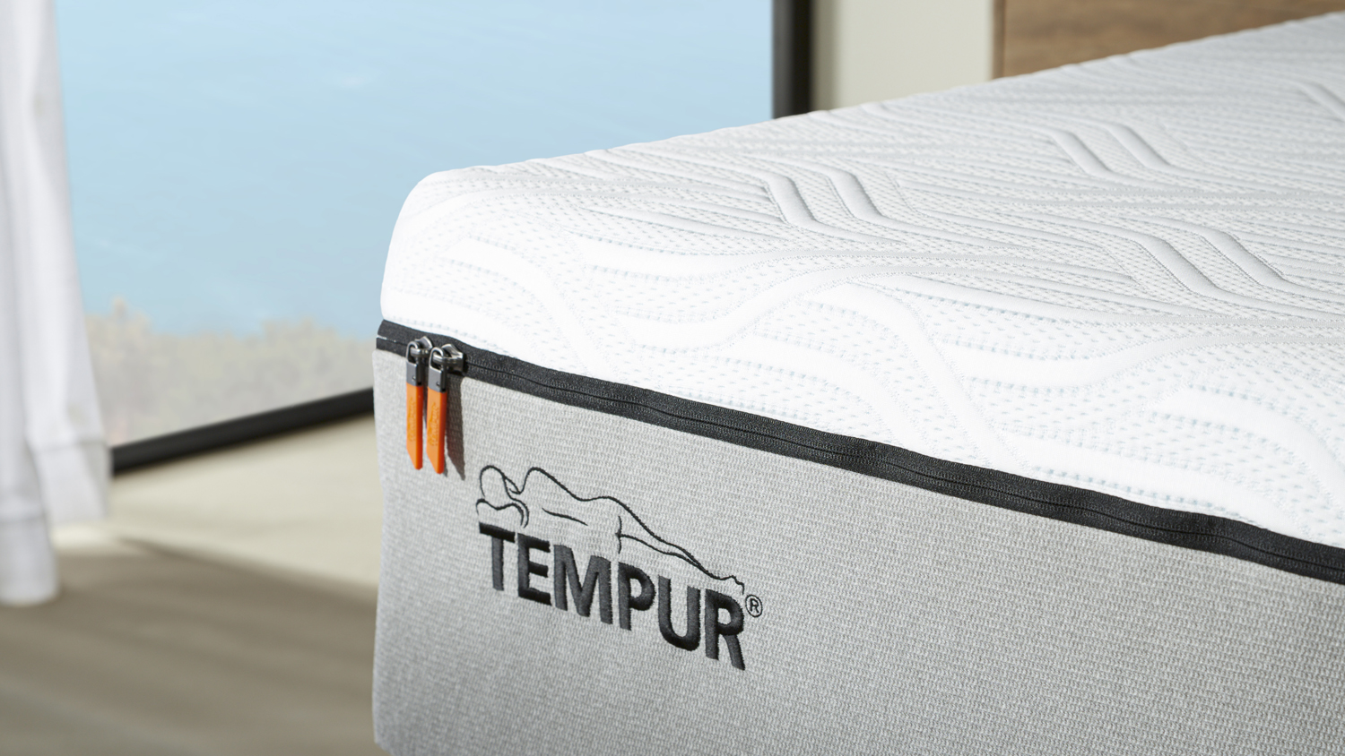 Detailed view showing the Tempur embroidered logo and premium zipper finish on the mattress cover