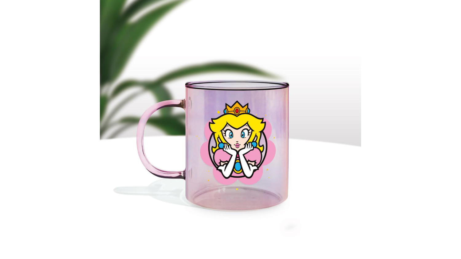 Transparent pink Paladone iridescent glass mug with a Princess Peach graphic, placed on a white surface with a soft plant shadow