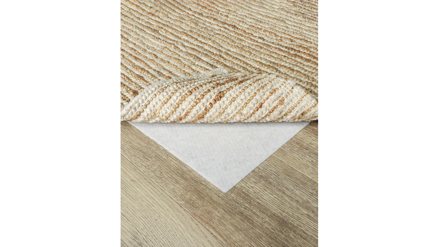 RugMaster anti-slip underlay placed beneath a textured beige rug on a wooden floor surface