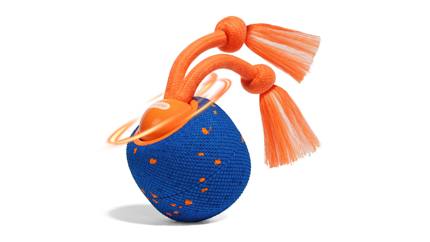 A blue textured Cheerble Wicked dog ball with orange flecks and a tassel rope handle, shown with a motion swirl