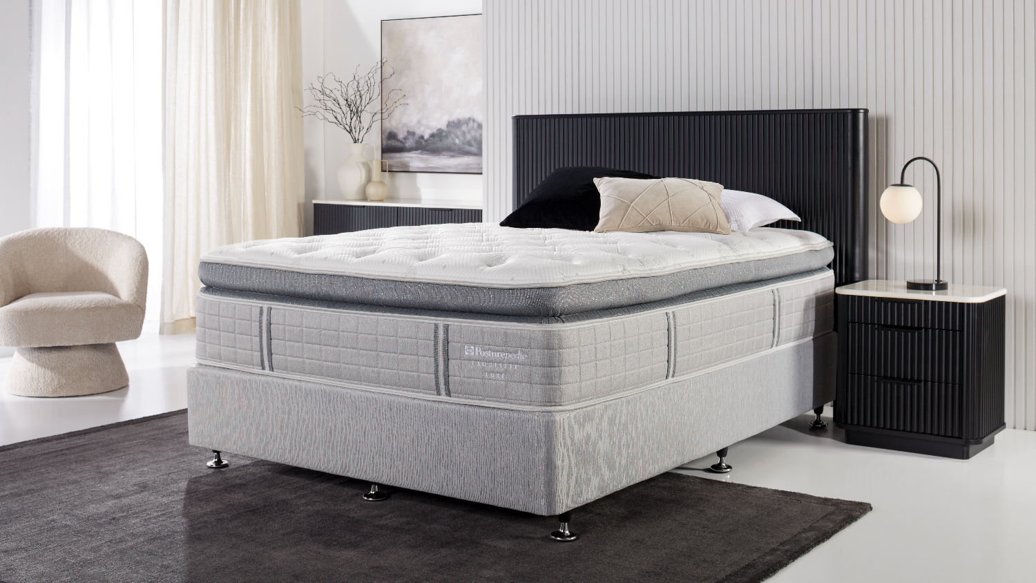 A Sealy Posturepedic Exquisite Boutique Soft King Mattress on a bed frame in a modern, neutral-toned bedroom