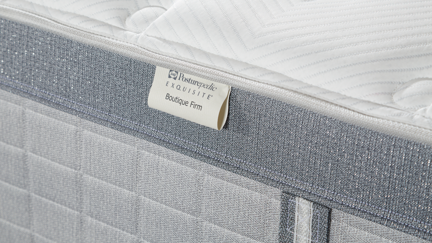 Close-up view of the Sealy Posturepedic mattress, highlighting the product tag