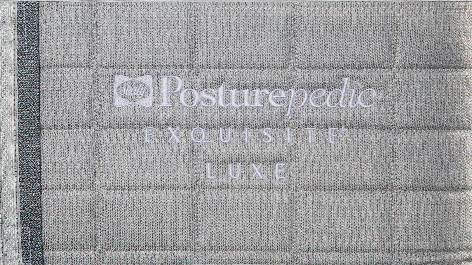 A close up view of the mattress' embroidered posturepedic logo