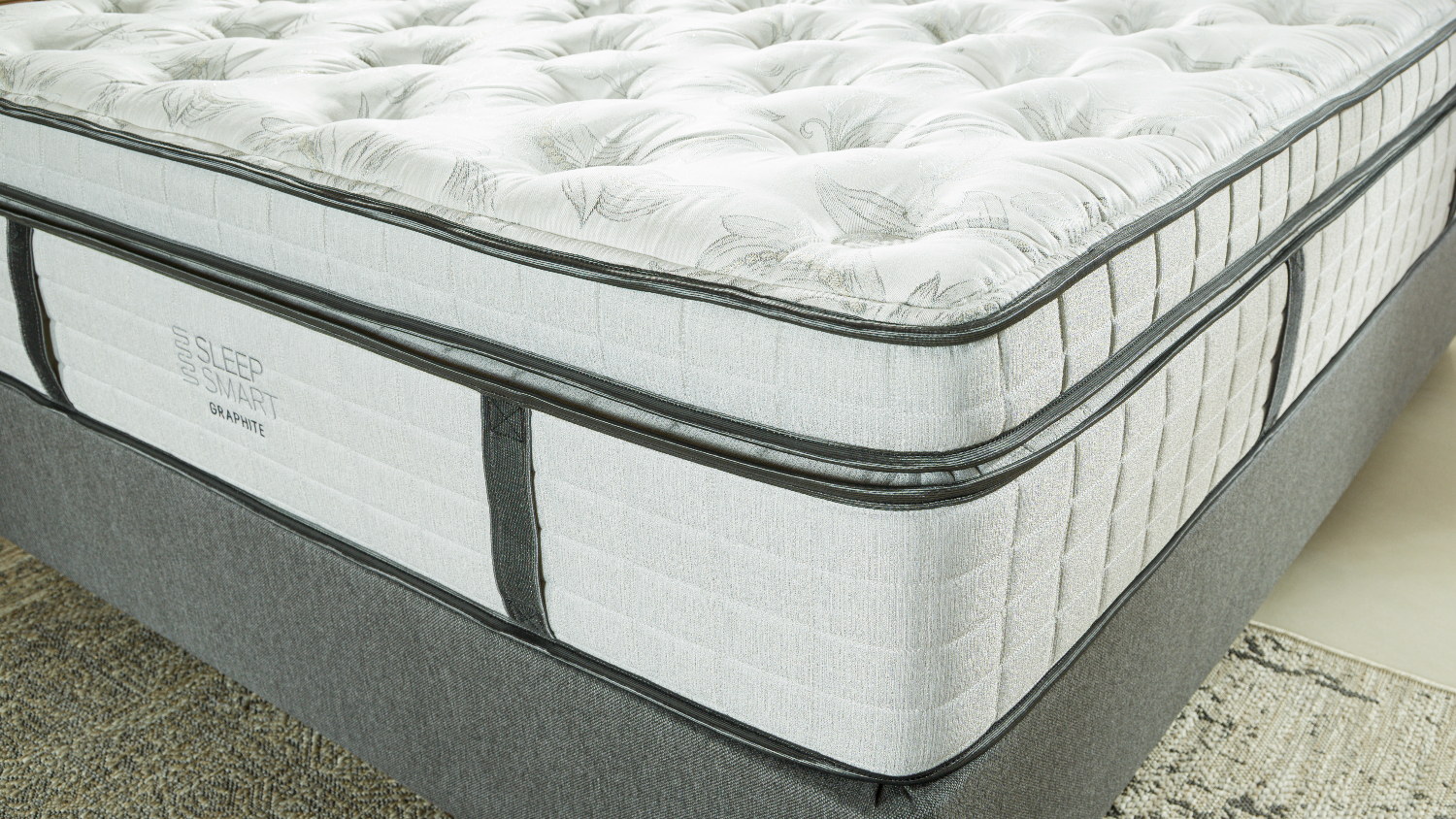 Close-up of the Sleep Smart soft mattress, showcasing its white quilted top and grey side panel design
