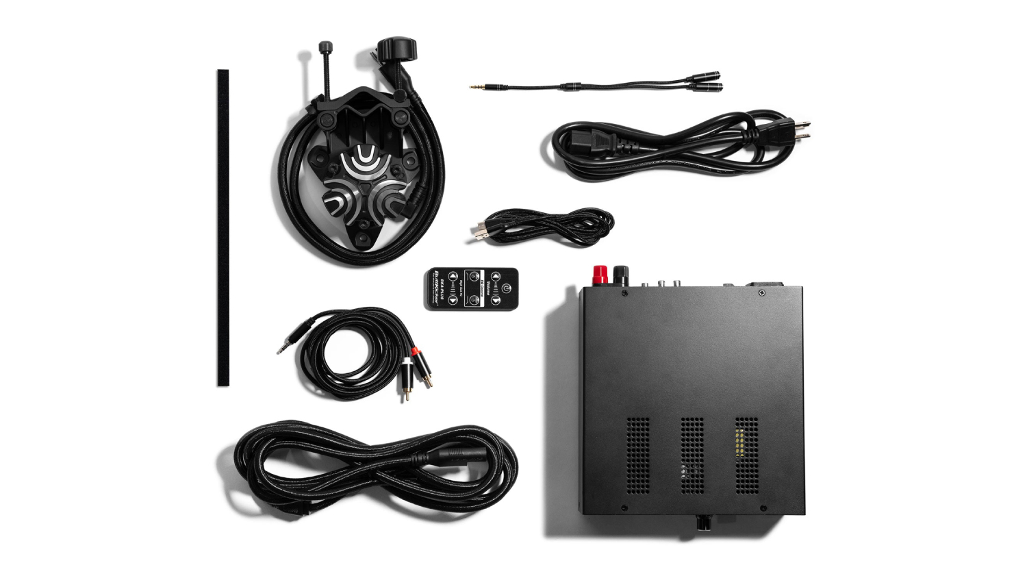 ButtKicker Gamer PLUS kit with amplifier, haptic transducer, mounting bracket, remote control, cables, and accessories