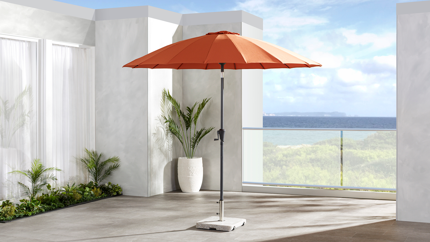 Raglan 2.7m outdoor umbrella with a rust polyester canopy and black steel centre pole, displayed open on a patio