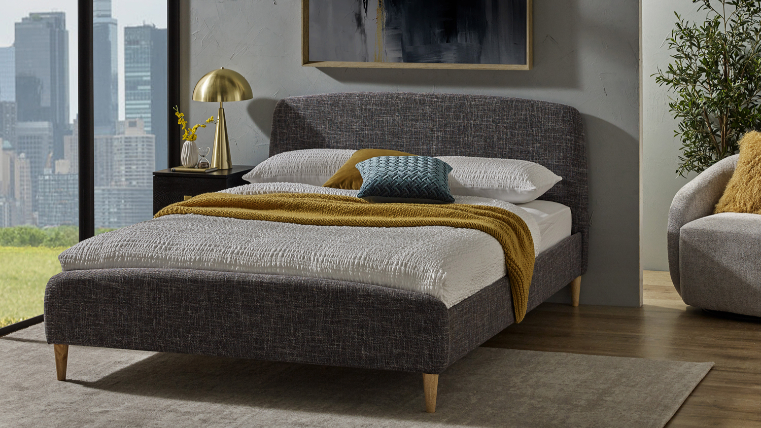 Angled view of the Bobby Queen Upholstered Bed Frame with textured dark grey fabric upholstery