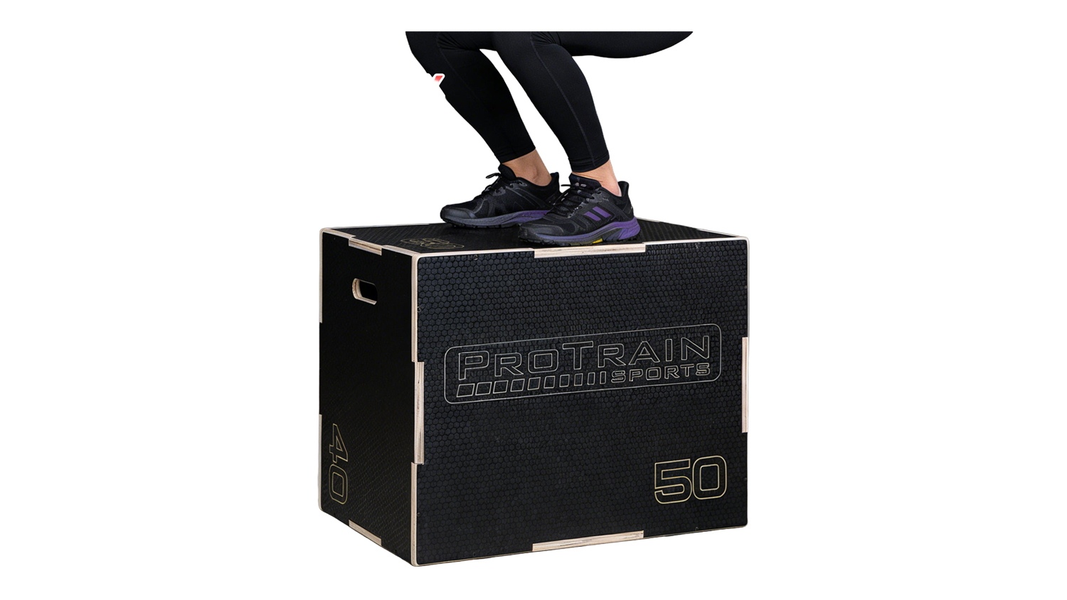A person wearing black athletic shoes landing on a Pro Train black wooden plyo box