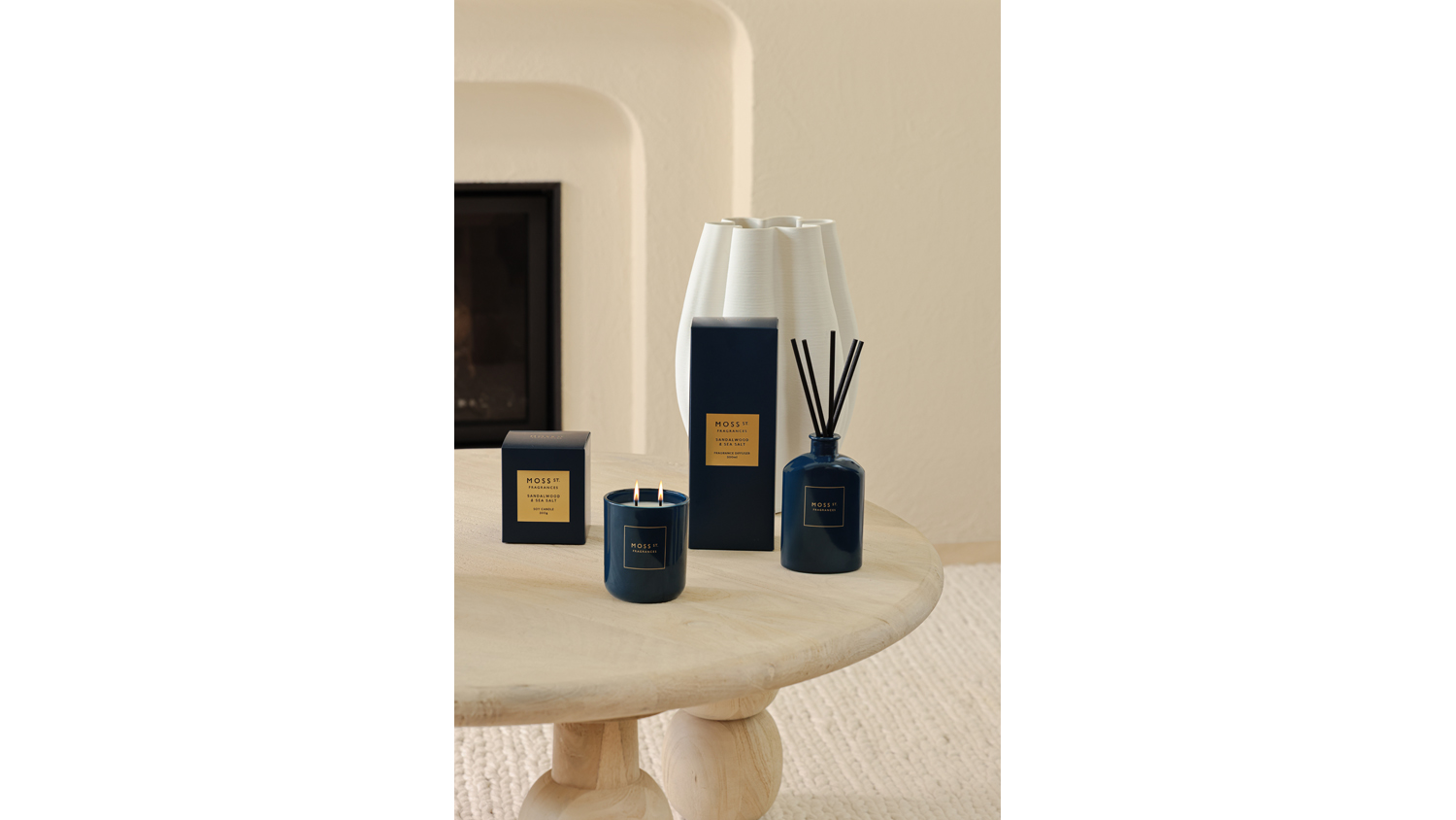 Warm setting highlighting a reed diffuser and candle on coffee table