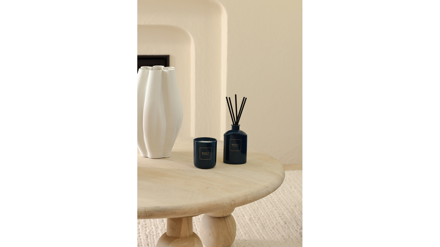 Warm setting highlighting a reed diffuser and candle on coffee table