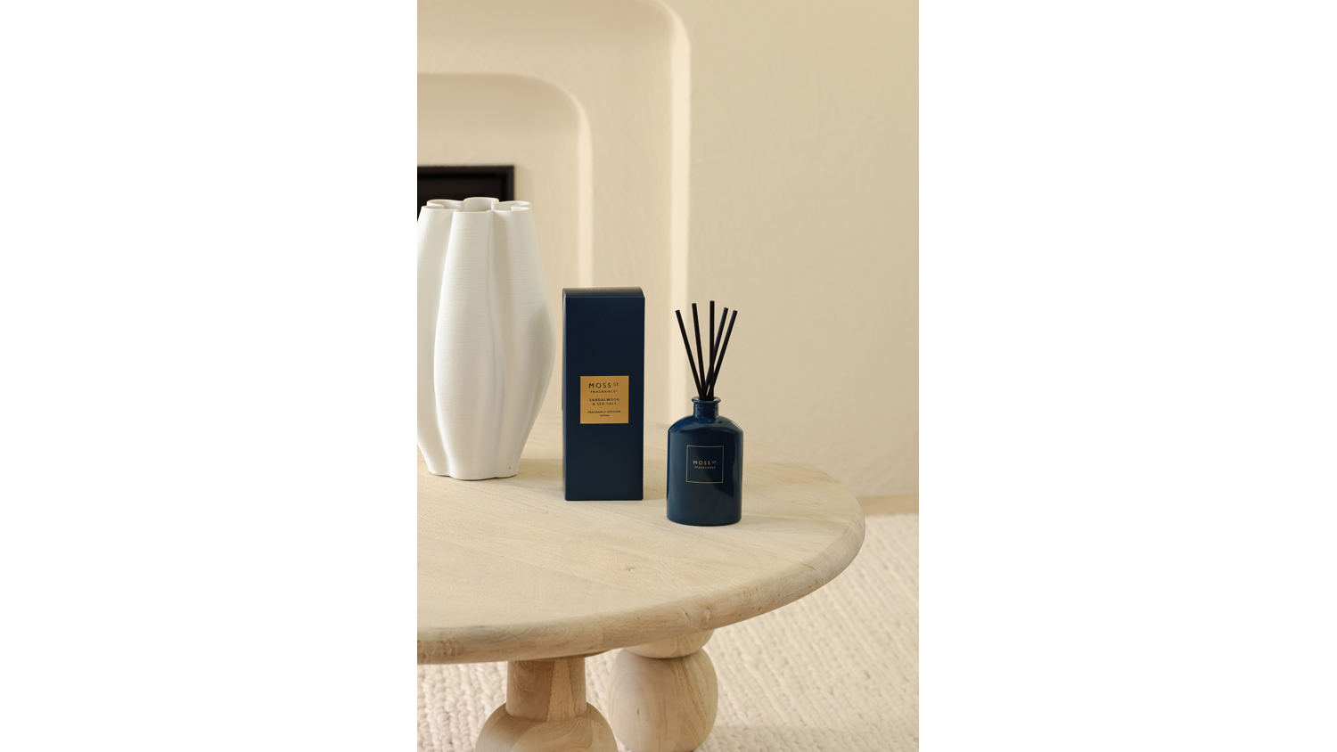 Minimalist room featuring a blue diffuser and box near a white vase